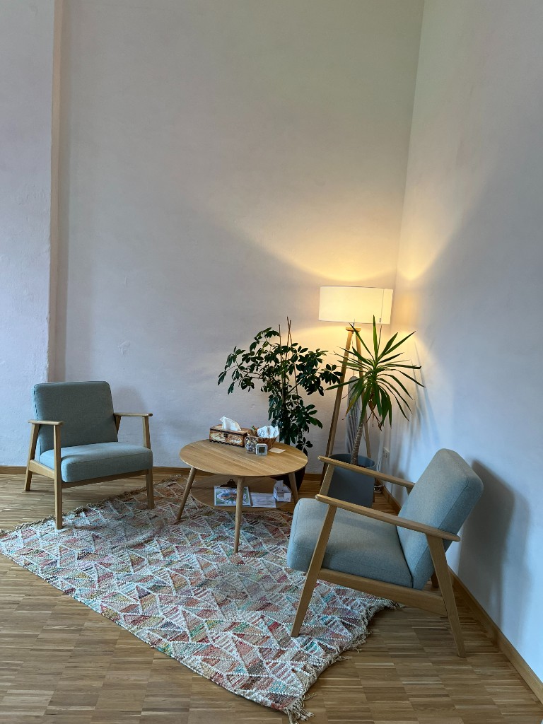 Gemütliche Sitzgruppe im Empfangsbereich der Praxis mit Sesseln und warmer Beleuchtung